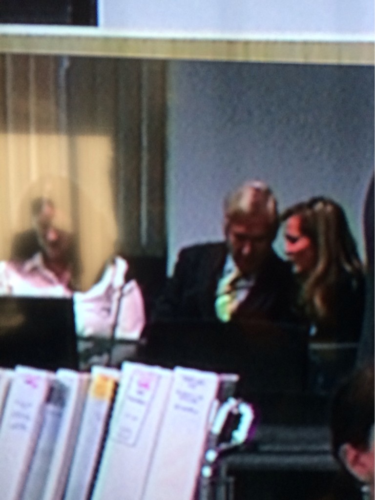 Jackson whispering in Lawlers ear while Bolano's girlfriend checks her phone 